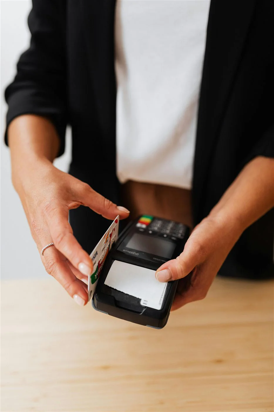 Persona manipulando terminal de pago con tarjeta en un negocio